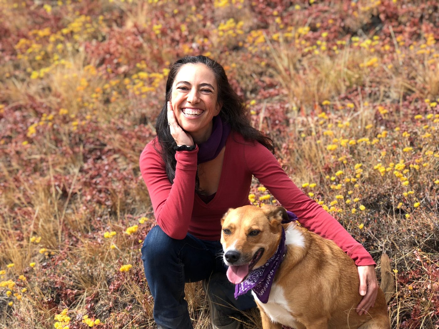 Asha with her dog Tara in a wildflower field